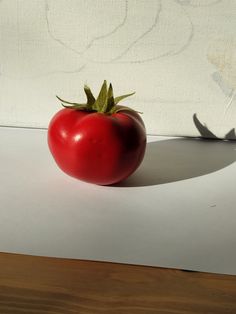 a red tomato sitting on top of a table