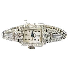 Presenting a: Vintage Art Deco 14K White Gold Hamilton 2.5ctw Diamond Watch 6.4" 22.1g Natural Diamonds approximately 2.5ct total. Measures .60" wide and 6.4" long. Marked 14K Weighing 22.1g Ships in a jewelry gift box. Luxury Silver Diamond Watch In Art Deco Style, Diamond Rectangular Watch For Anniversary, Art Deco White Gold Diamond Jewelry And Watches, Classic Diamond Watch Hallmarked, Classic Hallmarked Diamond Watch, Luxury Diamond Hallmarked Watch, Art Deco Diamond Watches With Diamond Accents, Antique Hallmarked Diamond Watch, Diamond White Gold Hallmarked Watches