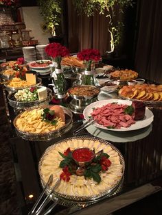 a buffet table filled with lots of different types of food on plates and serving platters