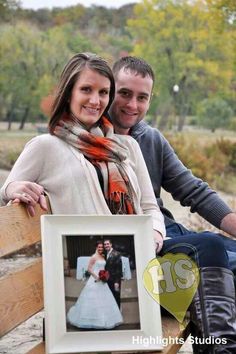 a man and woman are sitting on a bench with a picture frame in front of them