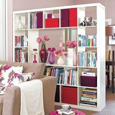 a living room filled with lots of furniture and bookshelves covered in pink flowers