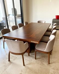 a large wooden table surrounded by beige chairs