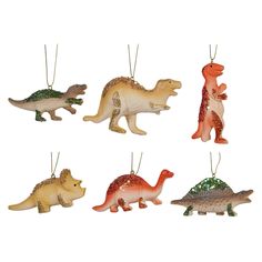 four dinosaur ornaments hanging from strings on a white background, each with different colors and sizes