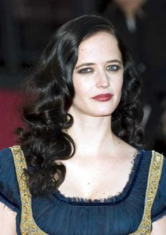 a woman with long black hair wearing a blue dress