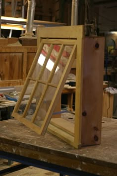 an open window sitting on top of a wooden table in a room filled with tools