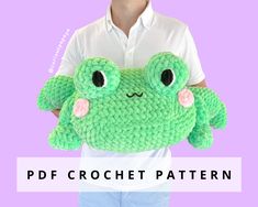 a green crocheted stuffed animal with big eyes