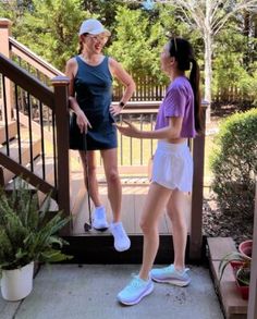 two women standing on the porch talking to each other