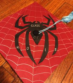 a red and black spiderman graduation cap with the words class of 2013 on it