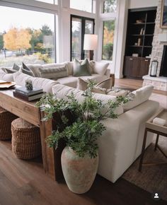 a living room filled with furniture and a large window covered in lots of natural light