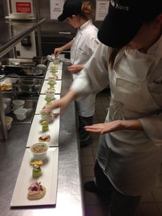 two chefs preparing food in a commercial kitchen