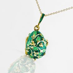 "Jewelry locket pendant with the frog surprise inside. Enameled and 24 K gold plated over solid sterling silver, this pendant is designed and made in our NJ shop in the tradition of Faberge jewelry. A green frog , in a color, matching the outside surface of the pendant, sits on white leaves, and is fixed steadily inside the locket. The egg is 20 mm (0.7\") long without a bail for a chain. It comes with 18' sterling silver gold plated chain and in a gift box. If you feel that you need a longer ch Oval Enamel Locket Necklace, Oval Locket Necklace In Enamel, Elegant Green Necklace For Keepsake, Enamel Locket Pendant Necklace, Art Nouveau Locket, Jewelry Locket, Faberge Jewelry, Green Pendant, White Leaves