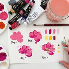 a person is painting flowers with watercolors and other paints on a white table