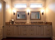 a bathroom with double sinks and two mirrors