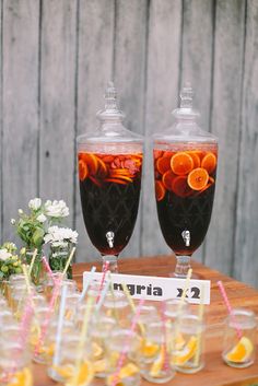 two glasses filled with liquid sitting on top of a wooden table next to each other