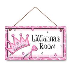 a pink and white sign with a princess crown on it's front hanging from a rope