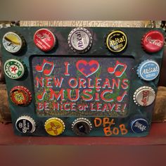 there is a sign made out of beer bottle caps and magnets that say new orleans music be nice of leave