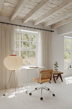 an empty room with a chair, table and lamp in it's centerpiece