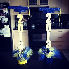 two vases with blue and yellow decorations in the shape of numbers are on a kitchen counter