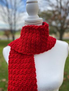 a red knitted scarf on top of a white mannequin