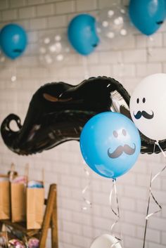 some balloons with mustaches on them hanging from the ceiling