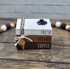 a stack of books with coffee tags tied to them on top of a wooden table