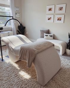 a bedroom with white carpet and pictures on the wall