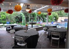 an outdoor dining area with tables and chairs covered in black and white checkered tablecloths