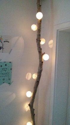 a branch with lights hanging from it in a room