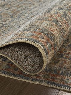 an area rug with wood flooring on top of it and a wooden floor in the background