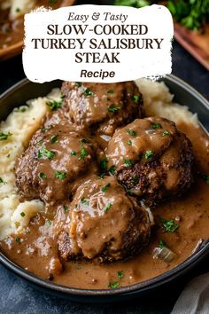 a bowl filled with meatballs and gravy on top of mashed potatoes