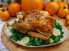 a roasted turkey on a platter surrounded by pumpkins