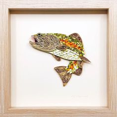 a fish made out of paper in a wooden frame