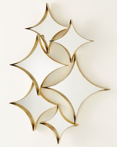 a decorative mirror hanging on the side of a wall with four different shapes in it