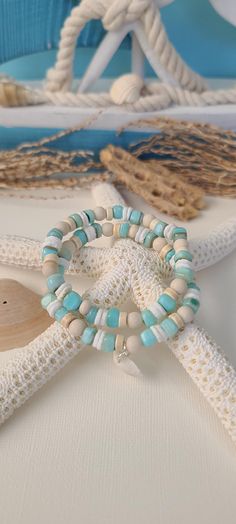 TitiTataStore.etsy.com Always FREE SHIPPING and a FREE GIFT! I Will Ship Within 24 Hours! Description: A Beautiful Set of 2 Coastal Style Ocean Inspired Beachy Bracelets. Materials: Aqua Shell Beads, 6mm Natural Matte Riverstone Beads, 6mm Natural Wood Beads, White Heishi Seashell Beads, and 6mm Rondelle Magnesite Beads.  A coastal Clam Shell charm adorned this Beachy Style set. Every bracelet is handmade using a high-quality elastic stretch cord for durability. Size: Each bracelet is suitable f Cheap Blue Beaded Bracelets For The Beach, Cheap Multicolor Beachy Jewelry, Cheap Beachy Beaded Bracelets For Beach Party, Cheap Beaded Bracelets For Summer Beach Party, Affordable Handmade Beaded Bracelets For Beach Season, White Coastal Style Bracelet For Gift, Coastal White Beaded Bracelets For Gift, Handmade Wrap Bracelet With Round Beads For Beach, Beachy Beaded Bracelets