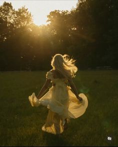 a woman in a dress is running through the grass