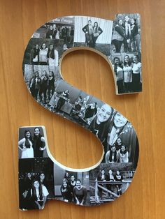 the letter s is made out of photos and has been placed on a wooden surface