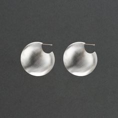 Named for the goddess of war, these shield like vessel earrings are powerful and the domed earrings are distinctly feminine. 1 1/2" in diameter and 1/2" wide the earrings nest close to your earlobe. The hollow forms are lightweight and a delight to wear. There is a mirror image texture detail that elevates the design. One side of the earring is high polish and the other has a soft matte texture. Big and bold, they're sure to make you feel invincible out in the world. FORM Collection Unique Round Earrings With Polished Finish, Silver Sphere Metal Earrings, Silver Crescent Hammered Earrings, Elegant Hand Forged Circle Earrings, Modern Round Hand Forged Earrings, Modern Hand Forged Round Earrings, Contemporary Handmade Round Earrings, Image Texture, Divine Feminine Art