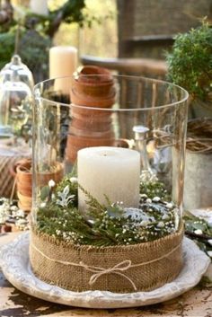 a table topped with a glass vase filled with candles