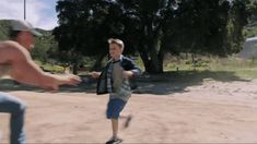 two men are playing frisbee in the dirt