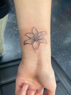 a small wrist tattoo with a flower on it