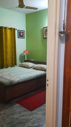 a bed room with a neatly made bed and green walls