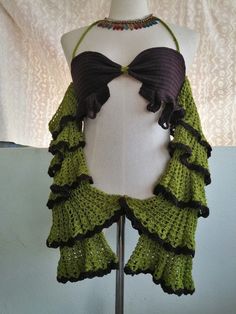 a mannequin wearing a green and black top with ruffles on it