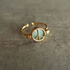 Now more than ever, peace and love my friends ☮ Adjustable ring from size 49 to size 60. 1 turquoise stone of 10 mm. Turquoise represents luck, peace and protection. Gold plated brass alloy base. Attention, the natural stones are all unique and may have slight color differences compared to that presented on this site. All my jewelry comes with an organza pouch. Adjustable Gold Spiritual Turquoise Ring, Adjustable Gold Turquoise Ring In Spiritual Style, Adjustable Gold Turquoise Ring, Gold Adjustable Turquoise Ring, Gold Turquoise Open Ring As A Gift, Gold Turquoise Ring Gift, Gold Turquoise Ring For Gift, Unique Gold Turquoise Ring Gift, Hippie Brass Jewelry Gift