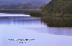 a lake with mountains in the background and a bible verse written on it's side