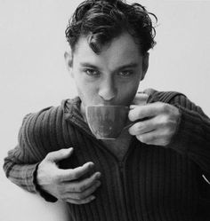 black and white photograph of a man drinking from a cup