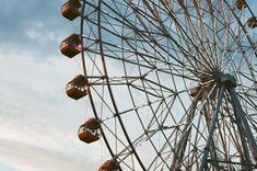 a large ferris wheel sitting under a cloudy blue sky