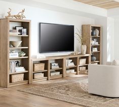 a living room filled with furniture and a flat screen tv on top of a wooden entertainment center