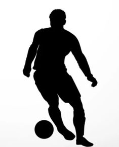 a silhouette of a man kicking a soccer ball