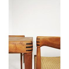 two wooden chairs sitting next to each other on top of a white floored room