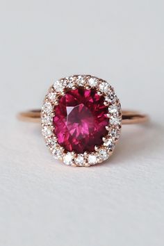 This rare pink-purple Umbalite brings me joy whenever I’m near it. Skillfully set in a tight low-profile multi prong design with a frame of post-consumer reclaimed single cut diamonds. Spiraling varied sized rubies enwrap the delicately crafted gallery for a dainty minimal design that yet packs a lot of gem power and vivacious energy. Umbalite is a new variety of Garnet that was discovered in Tanzania around 2015. Pink Lab-created Ruby Ring With Brilliant Cut, Pink Brilliant Cut Lab-created Ruby Ring, Red Pink Sapphire Jewelry With Brilliant Cut, Red Brilliant Cut Pink Sapphire Jewelry, Pink Ruby Ring With Rose Cut Diamonds, Red Jewelry With Pink Sapphire And Prong Setting, Rose Gold Ruby Ring With Ethical Diamonds, Fine Jewelry Ruby Halo Ring With Prong Setting, Ruby Gemstone Halo Ring With Round Cut